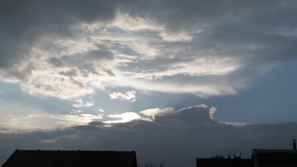 Nuvens bonitas após a chuva. no meio do céu claro sob a inscrição. os topos dos telhados abaixo — Vídeo de Stock