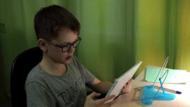 Çocuk tabletteki uzak bir derse bağlanıyor.