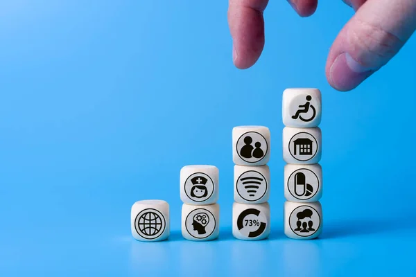 Concept of disability with icons on wooden cubes. on a blue background. Concept of care for the disabled.