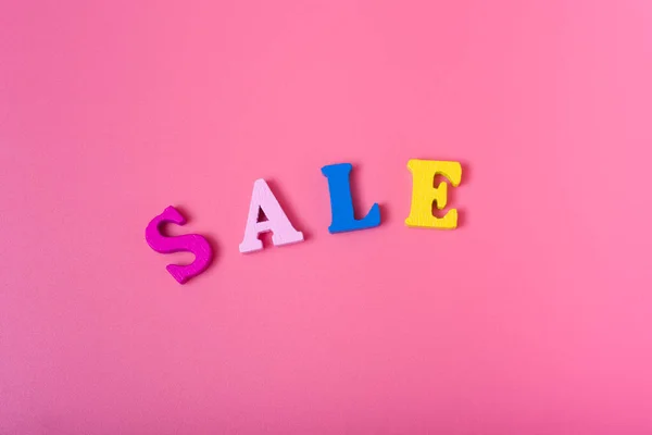 The word sale on a pink background of multicolored letters. concept of sales and discounts.