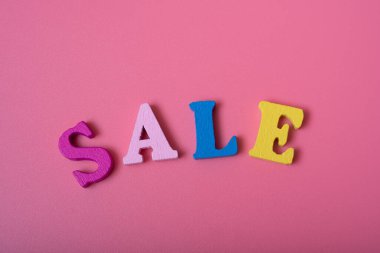 Renkli harflerin pembe arka planındaki kelime satışı. Satış ve indirim kavramı.