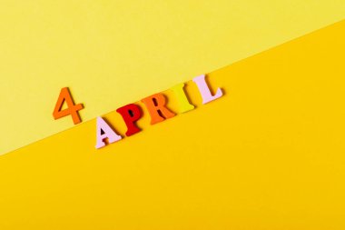 Sarı arka planda, 4 Nisan tarihli ahşap harfler. Qing Ming Festivali.