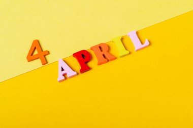 Sarı arka planda, 4 Nisan tarihli ahşap harfler. Qing Ming Festivali.