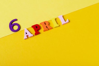 Sarı arka planda 6 Nisan tarihli ahşap harfler. Uluslararası Spor Günü ve Kalkınma ve Barışın Yararları.