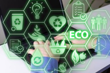 Teknoloji ekolojik arayüzü, bir teknoloji arayüzünde gösterilen ikonla görüntüleniyor. Eller dizüstü bilgisayarda ve ekoloji simgelerinde..