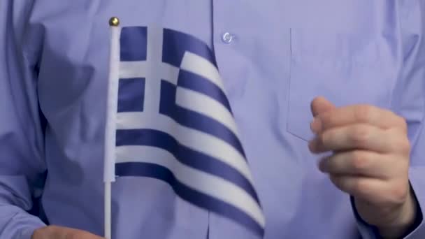 Прапор Греції Руках Чоловіка Чоловік Блакитній Сорочці Вказує Грецький Прапор — стокове відео