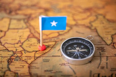 Dünya haritasında ve uçağında uçak bayrağı ve pusula. Seyahat ve turizm kavramı.