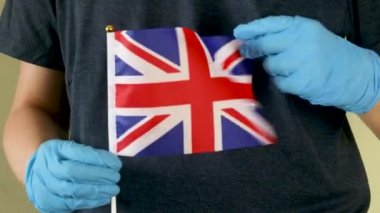 Büyük Britanya bayrağını açık havada tutan bir adam. Bağımsızlık Günü ya da ulusal bayram. Büyük Britanya 'nın harika ülkesi kavramı.