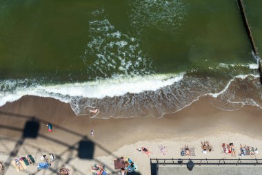 Zelenogradsk Haziran 2021, Baltık Denizi kıyısındaki kumda dönme dolabın gölgesi. Eğlence ve eğlence kavramı..