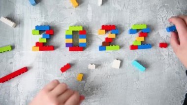 Yalıtılmış gri arkaplanlı ve metin için yeri olan çocuk inşaatçısından 2022 numaralı çok renkli sayılar