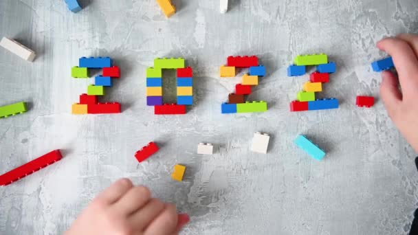 Números multicolores 2022 de niños constructor conjunto sobre fondo gris aislado con lugar para el texto — Vídeo de stock