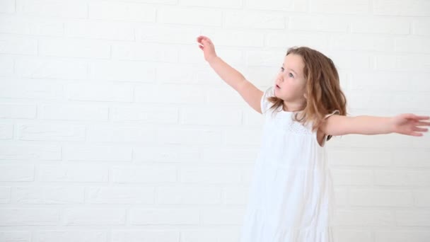 4歳の女の子が白いドレスを着て家で踊っていて — ストック動画