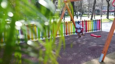 28,03,2021 İtalya, Napoli 'li küçük neşeli kız. 3 yaşında. Baharda salıncakta sallanıyor.