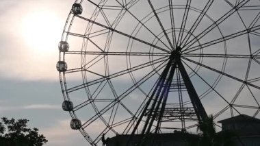 Akşam günbatımında dönme dolabın silueti.