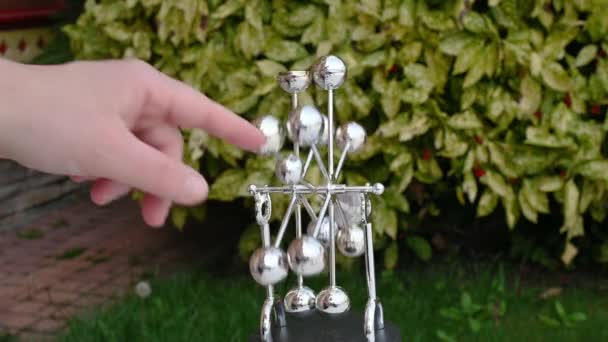 Abstrato metal brinquedo símbolo de máquina de movimento perpétuo no fundo verde — Vídeo de Stock