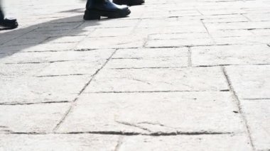 İnsanlar cadde boyunca şehir meydanında yürürler.