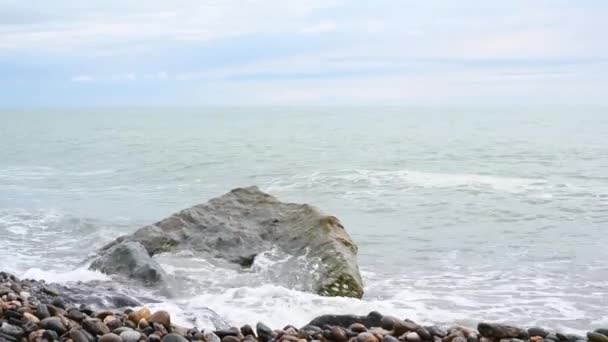 Vagues de la mer éclaboussent contre une pierre sur une plage de galets mer noire Sotchi Russie — Video