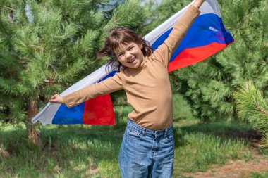 Genç kız yaz günbatımında Rus ulusal bayrağını taşıyor. Rusya günü, 12 Haziran. 22 Ağustos 'ta Rus bayrağının çekildiği gün. 4K