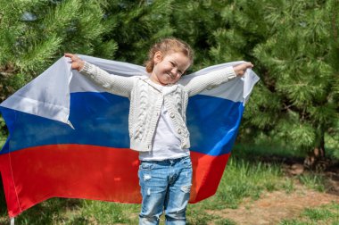 Genç kız yaz günbatımında Rus ulusal bayrağını taşıyor. Rusya günü, 12 Haziran. 22 Ağustos 'ta Rus bayrağının çekildiği gün. 4K