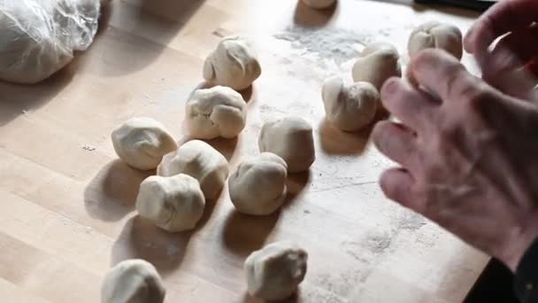 Грубі старі руки готують домашню їжу замішуючи розкачати тісто для пельменів чебуреки — стокове відео