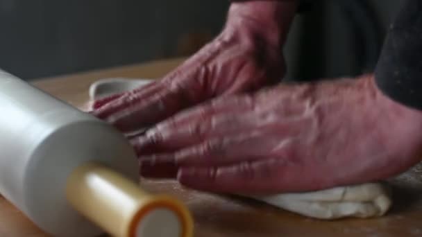 Скалка лежит на столе человек готовит тесто для чебуреков делает шары теста режет тесто с ножом концепции домашней пищи — стоковое видео