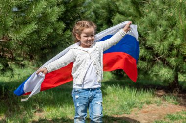 Genç kız yaz günbatımında Rus ulusal bayrağını taşıyor. Rusya günü, 12 Haziran. 22 Ağustos 'ta Rus bayrağının çekildiği gün. 4K