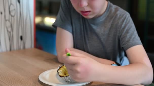 Schoolboy boy sitting in the park eating street food close-up — Stock Video