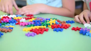 Çocuklar anaokulundaki yakın planda masada çok renkli parlak yapıcılar oynuyorlar.