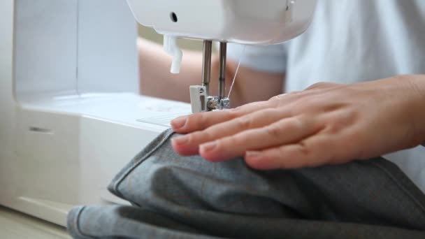 Costurera mujer cose en una máquina de coser cerca de las manos femeninas — Vídeos de Stock