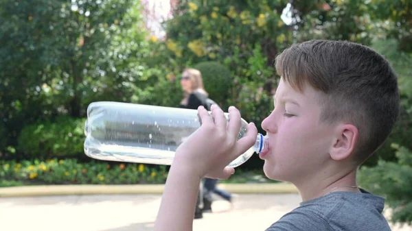 Schüler sitzt im Park und trinkt Wasser aus nächster Nähe — Stockfoto