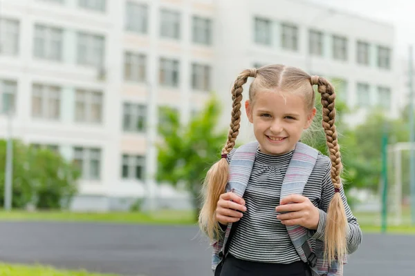 Carina ragazza 8 anni va a scuola con uno zaino — Foto Stock