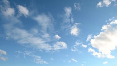 Mavi gökyüzünde beyaz bulutlar süzülür