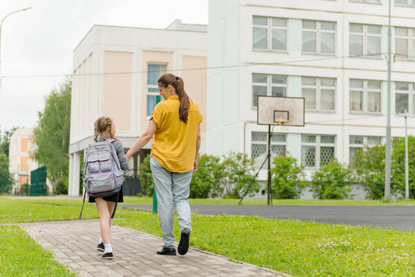 little happy girl with mom going to school education concept