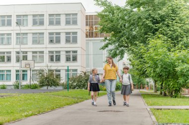 Annesiyle mutlu iki kız okul eğitimine gidiyor.