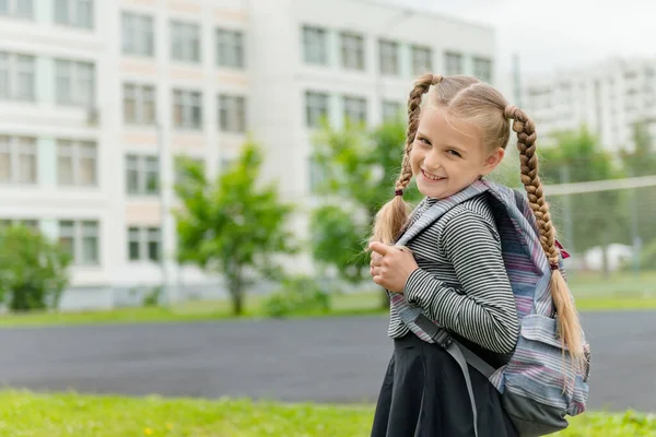 Carina ragazza 8 anni va a scuola con uno zaino — Foto Stock