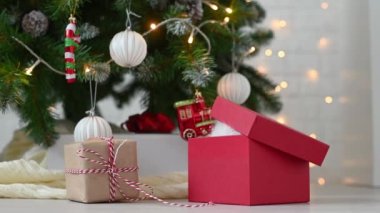 Noel ağacının arka planında yeni yıl süslemeleri ve yeni yıl konseptiyle oynayan sevimli kedi yavrusu.