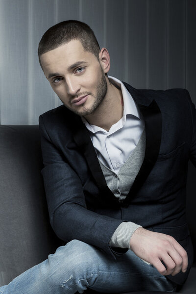 young business man sitting on a chair and looking at the camera 