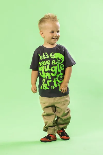 Cute little blond fashionable boy, green bacground — Stock Photo, Image