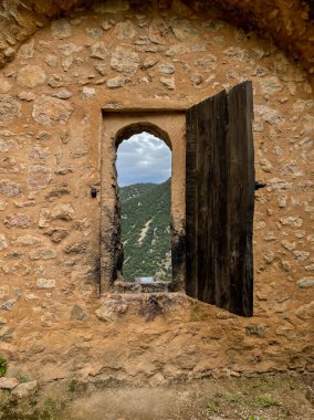 Ortaçağ taş duvarlarına ve bitkisel dağlara bakan ahşap kepenklere dikkat edin.