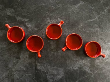 Kırmızı yuvarlak fırın ya da İspanyol aperatifleri gri taş arka planına karşı sıra halinde seramik