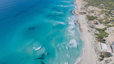 Turkuaz bir denizi ve insansız hava aracından görülen dalgaları olan inanılmaz bir sahil.