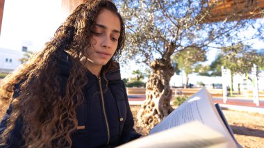 Parktaki genç Brezilyalı kız elinde kitapla