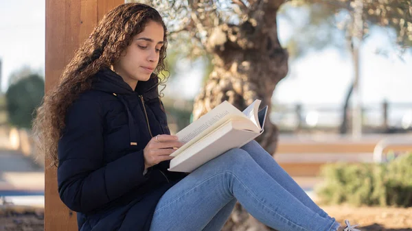 Parktaki genç Brezilyalı kız elinde kitapla