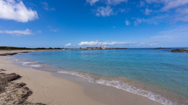 Şeffaf turkuaz suyu ve güneşli bir günde mavi gökyüzü olan cennette bir sahil..