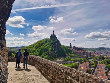 Seyyahlar, Camino de Santiago 'dan ayrılan Le Puy en Velay üzerindeki muhteşem manzaraya bakıyorlar. Fransa.