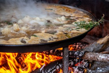 Geleneksel Valensiyalı paella pişirme süreci: İspanya 'da aroma Akdeniz mutfağı için biberiye filizi.