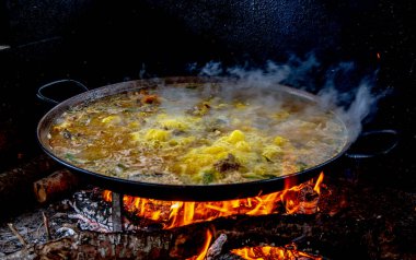 Geleneksel Valensiyalı paella pişirme süreci: İspanya 'ya pirinç eklemeden önce çorbayı kaynatmak.