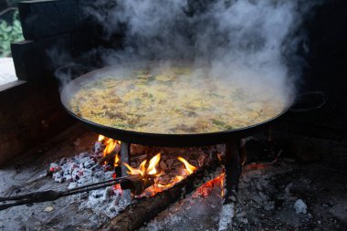 Geleneksel Valensiyalı paella pişirme süreci: İspanya 'da et suyu azaltmalı pirinç pişirme aşaması.