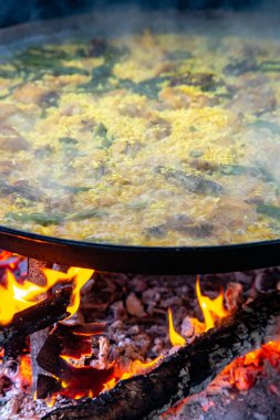 Geleneksel Valensiyalı paella pişirme süreci: İspanya 'da et suyu azaltmalı pirinç pişirme aşaması.