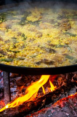 Geleneksel Valensiyalı paella pişirme süreci: İspanya 'da et suyu azaltmalı pirinç pişirme aşaması.